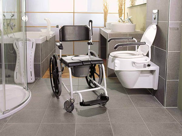 Mobiler Toilettenstuhl mit Rollen neben barrierefreier Toilette